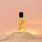 huile corps et cheveux jaune sur tas de sable fond coucher de soleil rose